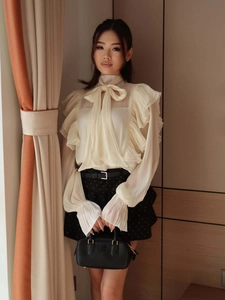 Detail of elegant chiffon blouse with large bow-tie neck and delicate ruffle edges