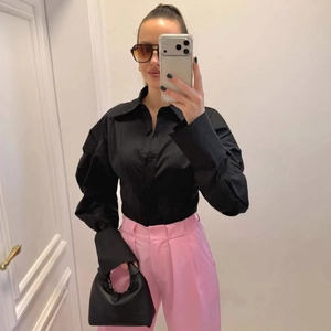 Elegant black lapel long sleeve shirt with puff sleeves paired with pink trousers