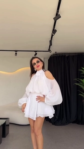 Detail of white off-shoulder dress with floral neckline and ruffled lantern sleeves