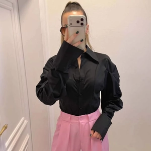 Women's black long sleeve shirt with exaggerated lapel and pink trousers set
