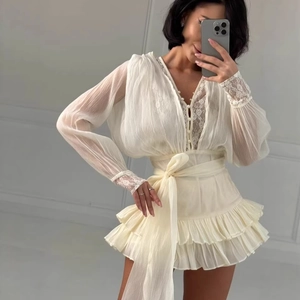 Elegante abito bianco avorio a maniche lunghe con pizzo e gonna a balze a strati