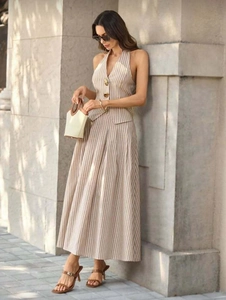 Detailed close-up of khaki striped halter top with golden buttons and pleated maxi skirt