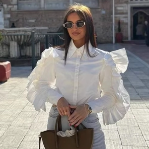 Fashionable white long-sleeve blouse with dramatic tiered ruffles and classic pointed collar