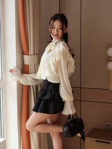 Elegant off-white ruffle collar shirt paired with a black polka dot layered skirt