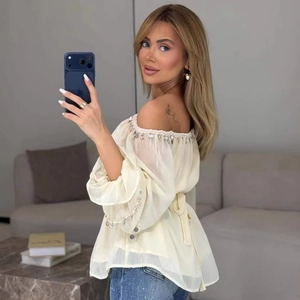 Chic off-the-shoulder cream chiffon blouse featuring tassel chain trim and waist tie belt