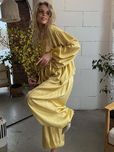 Detail of yellow satin loungewear set with lantern sleeves and wide-leg trousers