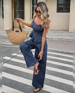 Detail view of the deep blue pinstripe wide-leg trousers and matching camisole set