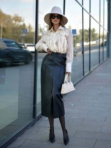 Detail of white ruffle long sleeve shirt paired with a black faux leather slit skirt