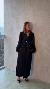 Dettaglio elegante camicia in raso nero con scollo a V e pantaloni a gamba larga