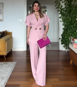 Detail of pink short-sleeve blazer and matching wide-leg trousers on model