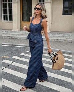 Detail of dark blue striped peplum camisole and wide-leg trousers on a fashion model