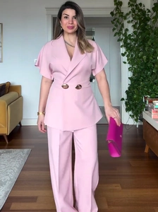 Detail of pink two-piece set featuring stylish metal buttons and professional waist tailoring