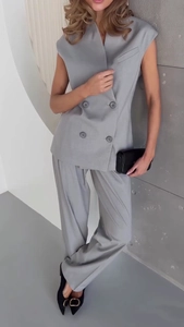 Detail of light gray sleeveless double-breasted vest paired with wide-leg suit trousers
