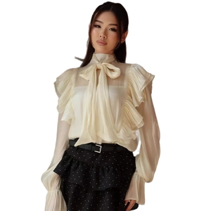 Elegant French style long sleeve blouse with ruffled layers and a large bow tie in beige