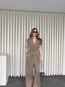 Détail du gilet sans manches kaki avec ceinture nouée et pantalon large taille haute