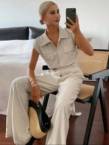 Detail of striped sleeveless top and high waist wide leg pants with belted waist design