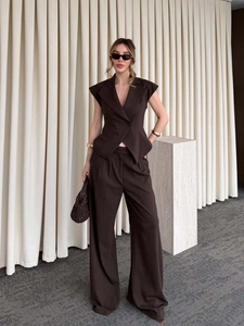 Détail d'un ensemble tailleur marron foncé sans manches avec pantalon large à taille haute