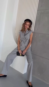 Detail of grey sleeveless double-breasted vest and high-waisted wide-leg trousers suit