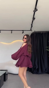 Detail of burgundy off-shoulder dress featuring ruffled layers and elegant lantern sleeves