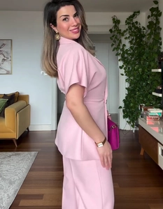 Detail of pink short sleeve blazer top and matching trousers set with high waist cut
