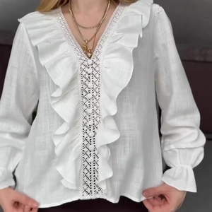 Elegant white V-neck blouse with ruffled sleeves and delicate lace hollow embroidery