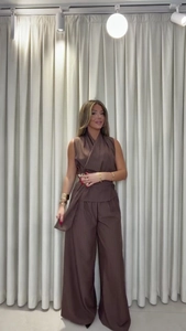 Detail of V-neck sleeveless wrap top and wide-leg trousers in brown ribbed fabric