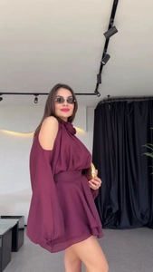 Detail of burgundy off-shoulder mini dress with floral accent and cinched waistline
