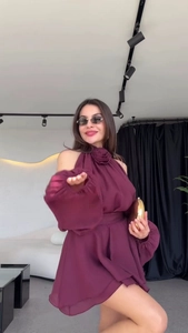 Detailed view of 3D floral accent on neck and exaggerated puff sleeves of burgundy dress