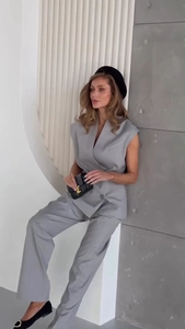 Detail of light gray double-breasted sleeveless vest and straight pants suit for women