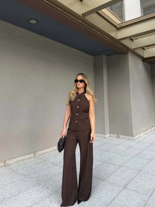 Detail of dark brown halter vest with gold buttons and matching wide-leg trousers