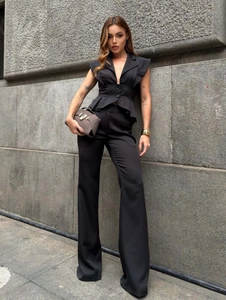 Detail of elegant black sleeveless vest with peplum hem and matching high-waist wide-leg pants