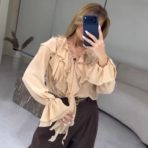 Blouse élégante en mousseline abricot clair avec volants, col en V et nœud papillon