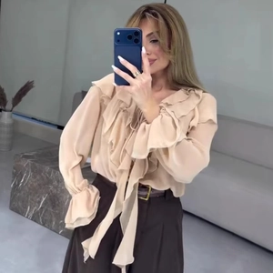 Blouse élégante en mousseline abricot avec col en V à volants et liens à nouer