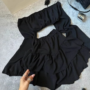 Schwarzes Damen-Zweiteiler-Set mit schulterfreiem Crop-Top und Volant-Minirock