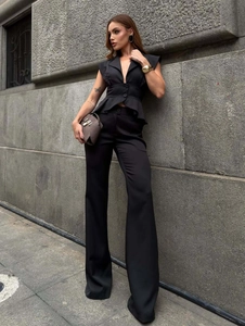 Detail of black V-neck sleeveless peplum top and high-waisted wide-leg trousers set