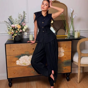 Sleeveless black two-piece set with gold buttons and subtle textured grid fabric