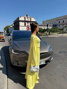 Three-piece lemon yellow set with long cardigan, crop top, and wide-leg trousers on a street
