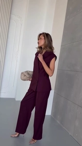 Detail view of burgundy double-breasted sleeveless blazer vest and high waist wide leg pants