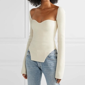 Dettaglio del maglione a coste color crema con scollo a cuore e orlo a V rovesciata