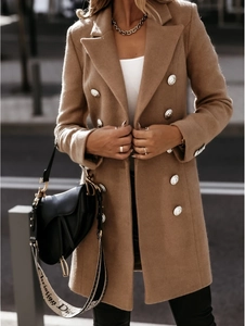 Detail of camel wool coat featuring double-breasted silver embossed metal buttons