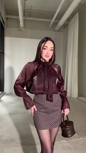 Dettaglio camicetta in raso con fiocco e gonna corta a pois per un outfit femminile elegante