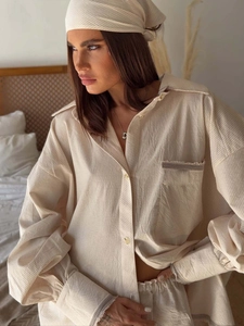 Detail of light beige striped linen set showing natural crinkled fabric texture and loose fit