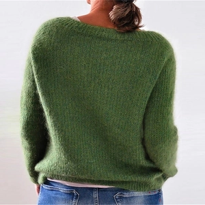 Dettaglio della morbida consistenza tipo mohair e della vestibilità ampia sul maglione verde