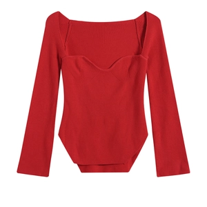 Dettaglio maglia rossa con scollo a cuore, trama a costine e cuciture in stile corsetto