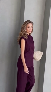 Detail of a dark purple double-breasted vest and matching wide-leg trousers professional set