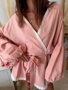 Detailed view of pink lace-trimmed wrap shirt with lantern sleeves and textured fabric