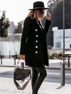 Detail of a black double-breasted wool coat with silver buttons in a street style setting