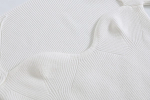 Dettaglio del tessuto bianco a coste con un elegante design dello scollo a cuore