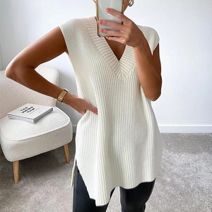 Close-up of white V-neck knitted vest featuring a side split and thick textured knit