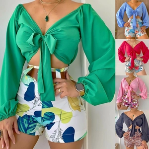 Detail of V-neck tie-front crop top and high-waisted printed shorts in vibrant colors